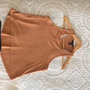 A tan tank top with a muscle cut look